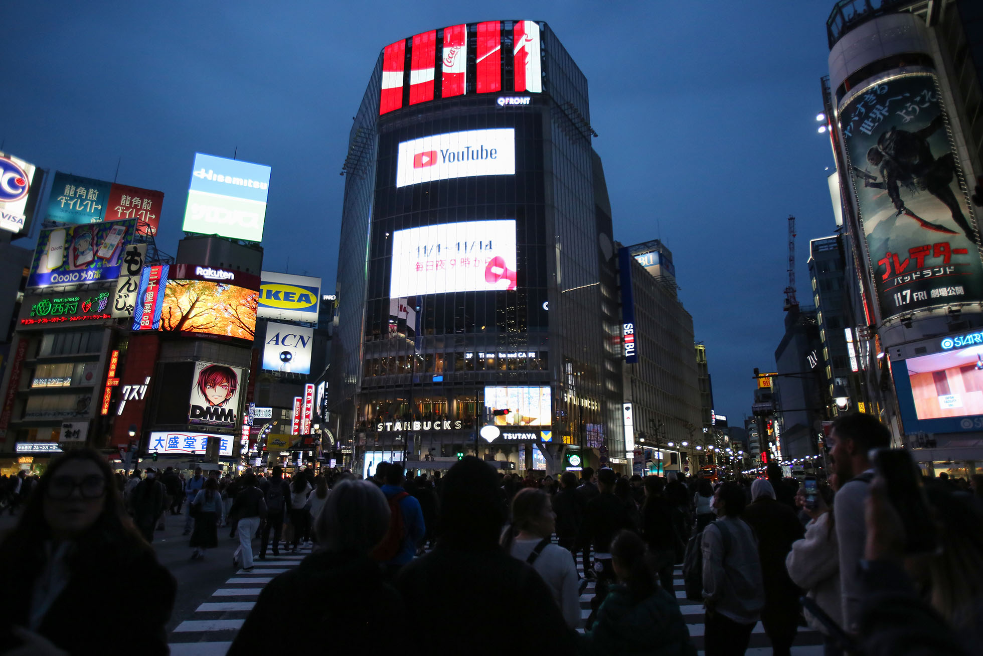 Persimpangan Shibuya Scramble saat senja. Penuh dengan wisatawan asing yang mengambil foto dan video dengan smartphone di tangan = Shibuya.