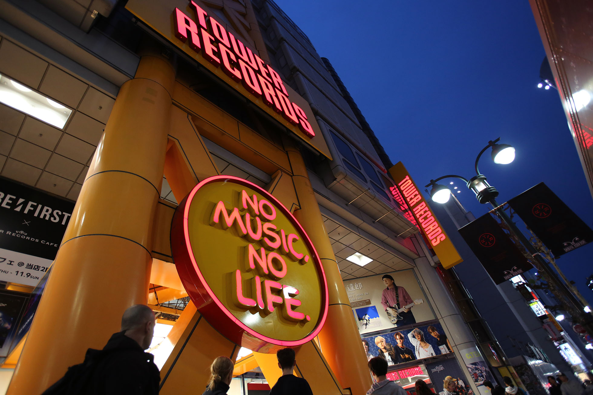 Tower Records dengan bangunan kuning dan neon merah yang bersinar = Shibuya.