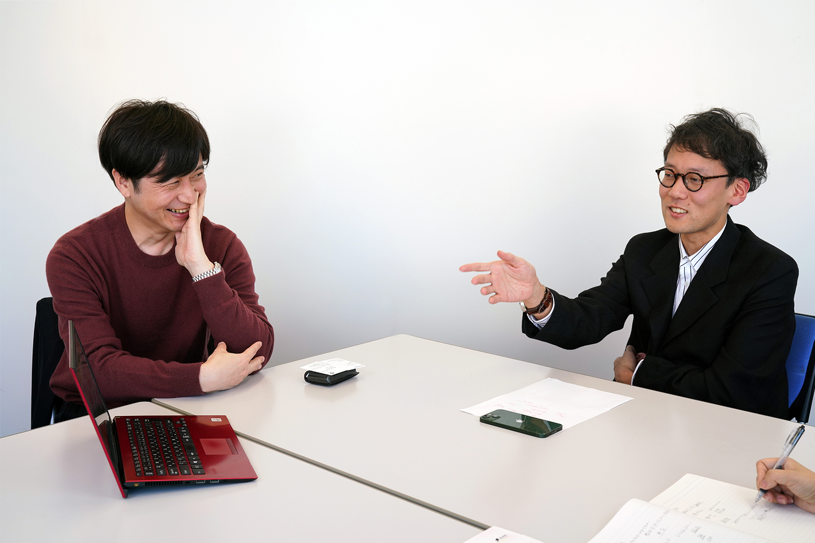 斎藤幸平さん（右）の話を笑顔で聞く、スコップ・スクールの岡本弘毅さん