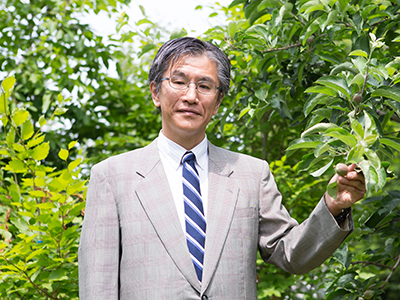 大学内にあるリンゴ見本園での石川隆二教授