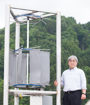 地域戦略研究所の本田明弘所長が開発した手作りの小型風力発電装置。漁業者がふだん使う帆布をブレードに活用するなど、メンテナンスをしやすい構造にしたのが特長だ