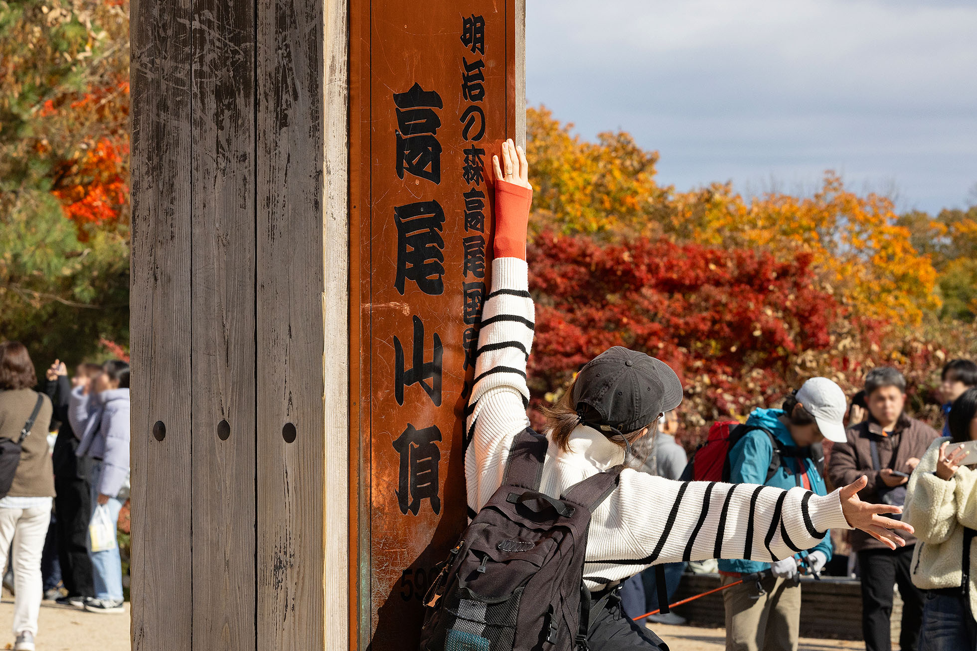 People take commemorative photos at the summit of Mount Takao.