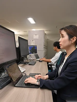 ２人の社員がパソコンでデータ分析をしている様子